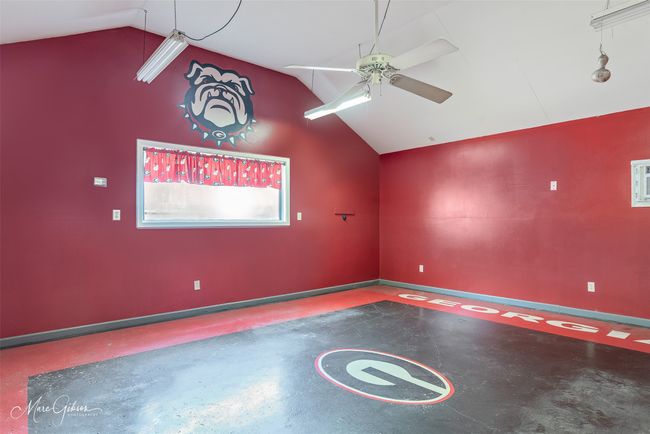 Unfurnished room with finished concrete floors, baseboards, ceiling fan, and vaulted ceiling | Image 22