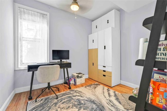 Office space with light wood-type flooring, a ceiling fan, and baseboards | Image 18