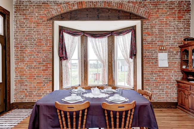 dining room featuring brick wall and light wood-style flooring | Image 18