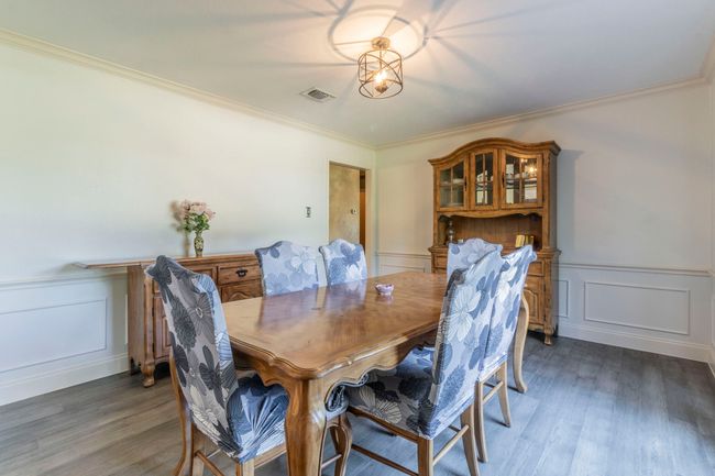 Dining room featuring a decorative wall, wood finished floors, ornamental molding, and a wainscoted wall | Image 8