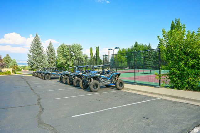 Uncovered parking lot with a tennis court and fence | Image 40