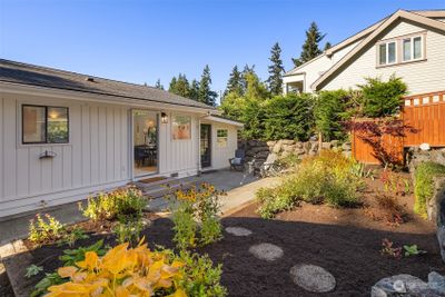 The front yard features sunny patio space, fuss-free gardens and easy access to the finished outbuilding | Image 2