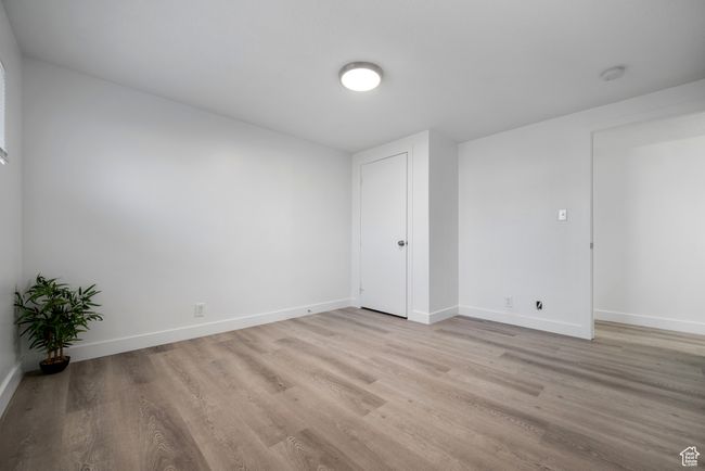 Unfurnished bedroom with light wood-type flooring and baseboards | Image 13