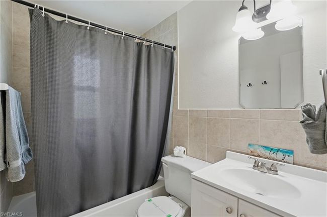 Bathroom featuring shower / bath combo, vanity, and tile walls | Image 29