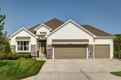 Craftsman-style house with a garage and a front lawn | Image 1