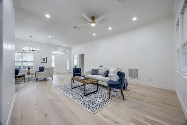 Living area with light wood-type flooring, a ceiling fan, recessed lighting, ornamental molding, and a chandelier | Image 7