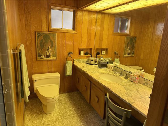 Full bathroom featuring toilet, vanity, wooden walls, and tile patterned floors | Image 32