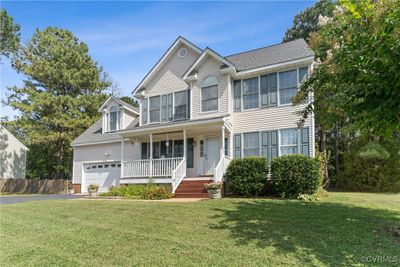 View of front of property featuring a garage, a front yard, and a porch | Image 1