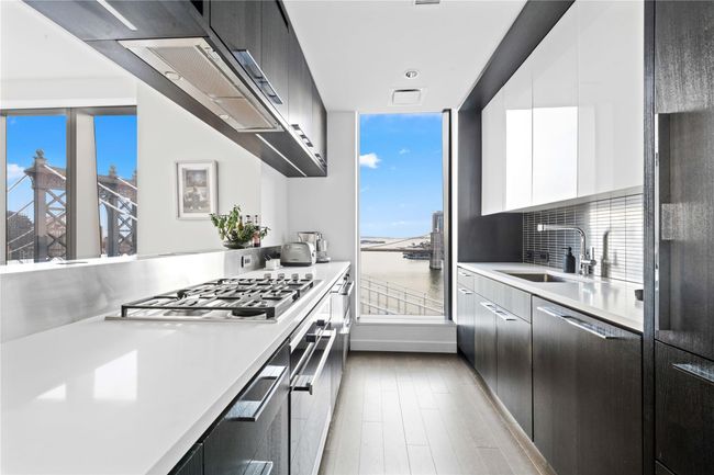 Kitchen with light countertops, modern cabinets, appliances with stainless steel finishes, and a sink | Image 5