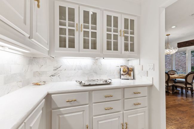 Quartz counters and upper glass door cabinets with gold finished drawer handles | Image 16