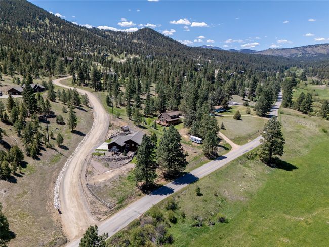 Aerial overview of property's location with a heavily wooded area and a mountain backdrop | Image 57