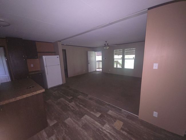 Kitchen with freestanding refrigerator, a ceiling fan, and dark wood finished floors | Image 6