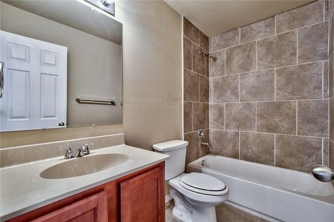 Full bath featuring vanity, shower / washtub combination, and a textured wall | Image 15