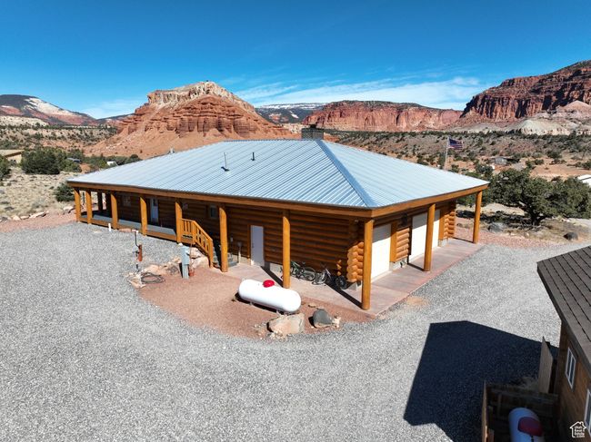 Log-style house featuring log siding, a mountain view, metal roof, and a garage | Image 42