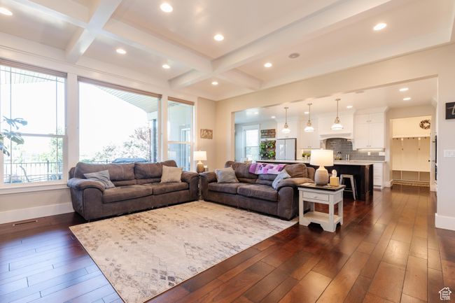Living room featuring dark wood-type flooring, coffered ceiling, plenty of natural light, recessed lighting, and beamed ceiling | Image 5