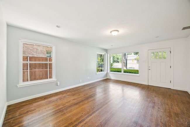 Expansive LIVING ROOM Situated at Front of Home Features Multiple Oversized Windows, Recessed Lighting, Neutral Colors, and Wood Floors | Image 4
