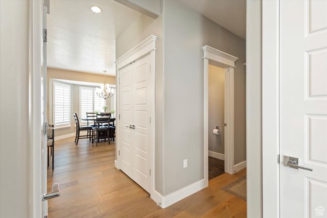 Hall with a chandelier, baseboards, and light wood-style floors | Image 16