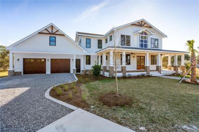 View of front of home with a front lawn, a garage, and covered porch | Image 1