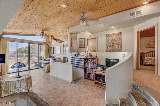 Living area with a ceiling fan, wooden ceiling, light tile patterned floors, french doors, and vaulted ceiling | Image 22