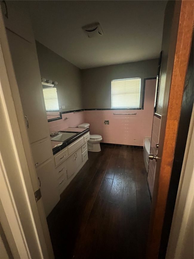 Bathroom featuring toilet, hardwood / wood-style floors, a tub, and vanity | Image 9