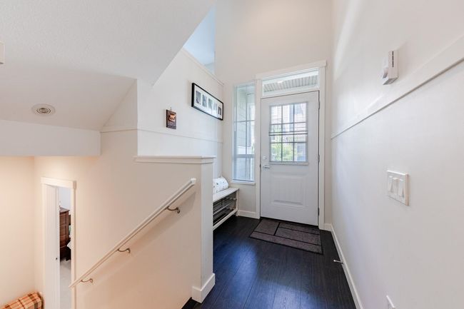 Doorway featuring dark wood-style flooring and lofted ceiling | Image 26