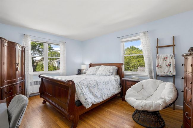 Bedroom with radiator heating unit and light wood floors | Image 13