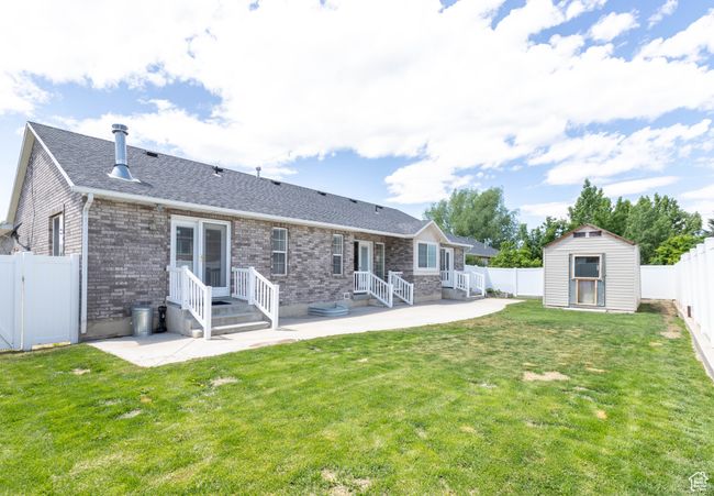 Back of house with a patio area, a shingled roof, and brick siding | Image 23