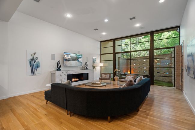 Living room featuring light wood-type flooring, a high end fireplace, expansive windows, recessed lighting, and​​‌​​​​‌​​‌‌​‌‌​​​‌‌​​‌‌​‌​​​​​‌ baseboards | Image 5
