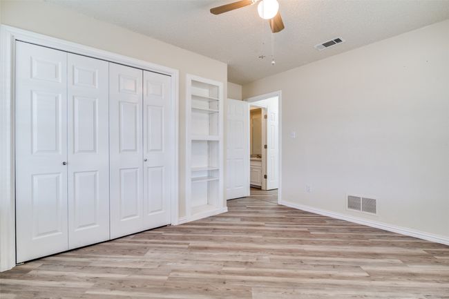 Unfurnished bedroom featuring a closet, visible vents, light wood finished floors, and a textured ceiling | Image 23
