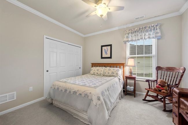 A second bedroom on the main level has a large double door closet and crown molding detail. | Image 21