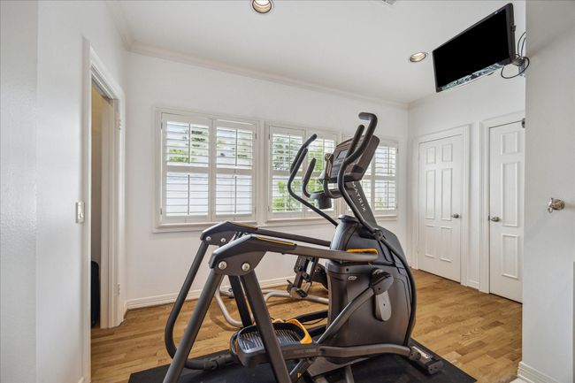 Extra living space in the primary bath that current owners have used for their workout space. But could be a nice relaxation area as well with this abundant natural light. Walk-in closets on either side of this space and behind the doors is extra storage! | Image 22