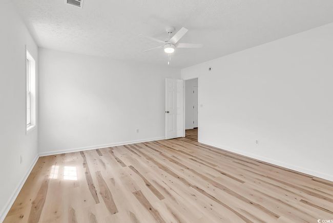 Unfurnished room featuring light wood-style floors, baseboards, ceiling fan, and visible vents | Image 15