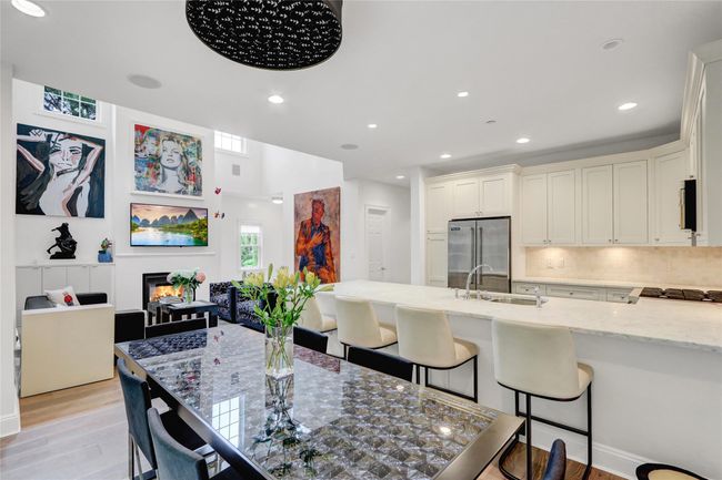 Dining space featuring light wood-style floors, a glass covered fireplace, and recessed lighting | Image 12