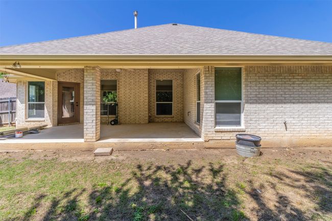 Rear view of property featuring brick siding, a patio, and a shingled roof | Image 33