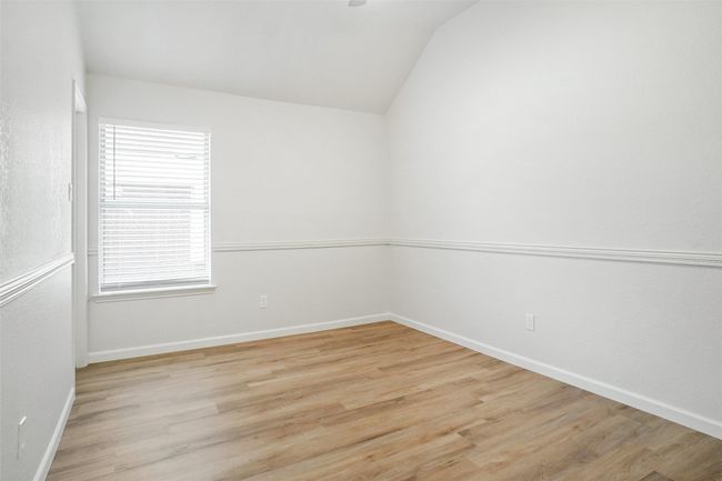 Spare room featuring lofted ceiling, light wood-style floors, baseboards, and healthy amount of natural light | Image 19