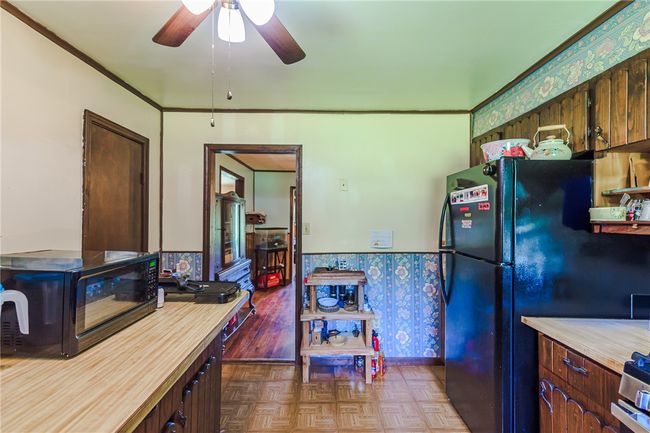 Kitchen featuring black appliances, ceiling fan, and wallpapered walls | Image 29