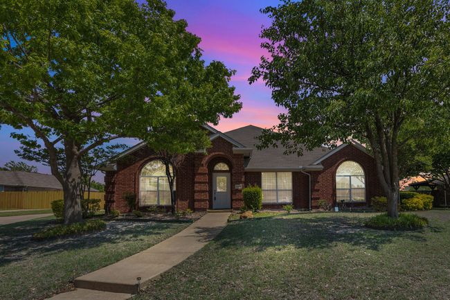 View of front facade with fence, brick siding, a front yard, and roof with shingles | Image 40