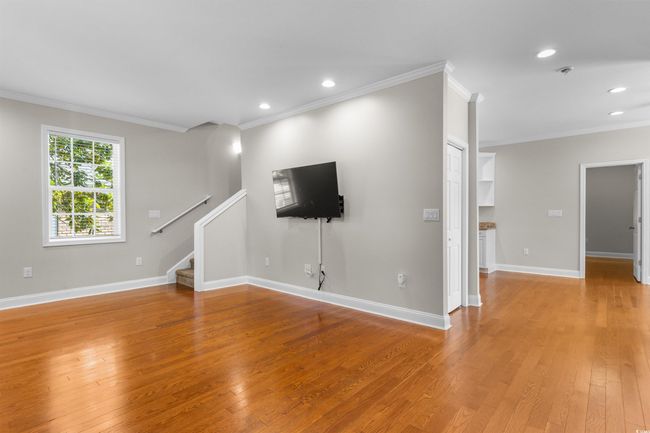 Unfurnished living room with ornamental molding, light wood-style floors, stairway, recessed lighting, and baseboards | Image 8