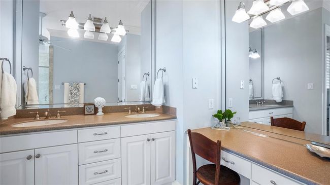 Off to the side, a mirrored vanity with sleek built-in drawers adds a touch of elegance and functionality to the space | Image 25