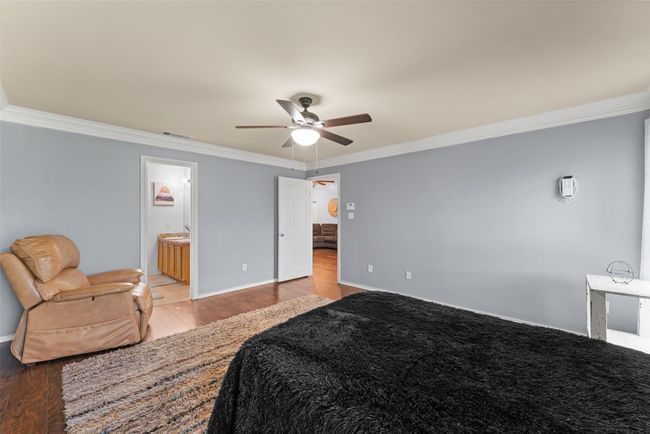 Bedroom featuring ornamental molding, wood finished floors, a ceiling fan, and connected bathroom | Image 16