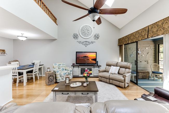 Living room featuring high vaulted ceiling, light wood-style floors, and ceiling fan | Image 7