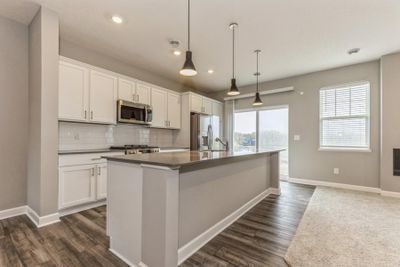 (Photo of an inventory home, actual homes finishes will vary) This spacious kitchen features a large center island, quartz countertops, LVP floors and more! | Image 1