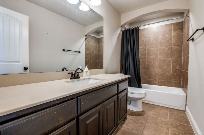 Bathroom with vanity, tile patterned floors, and shower / bathtub combination with curtain | Image 23