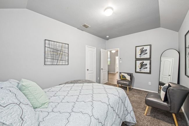 Bedroom with visible vents, baseboards, carpet floors, and lofted ceiling | Image 36