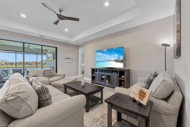 Living room with visible vents, a tray ceiling, recessed lighting, baseboards, and ceiling fan | Image 34