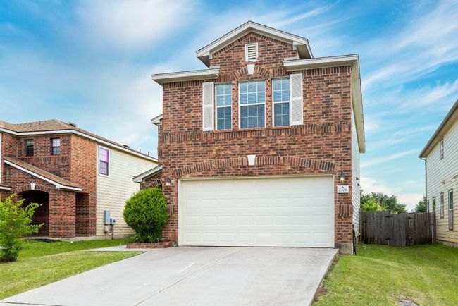 Traditional-style home featuring brick siding, a garage, and concrete driveway | Image 12