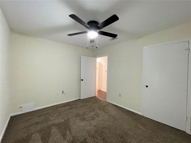Unfurnished bedroom featuring dark colored carpet and a ceiling fan | Image 25