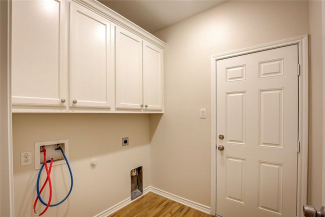 Laundry area with cabinet space, electric dryer hookup, hookup for a washing machine, light wood-type flooring, and gas dryer hookup | Image 28