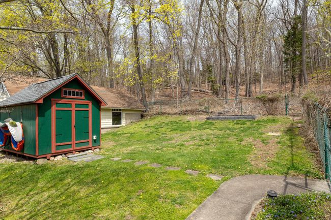 View of yard with a fenced backyard, an outdoor structure, and a storage unit | Image 32