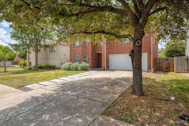 View of front facade with driveway, brick siding, and a garage | Image 35
